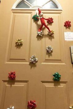 a door decorated with christmas decorations and an elf on the top of it's head