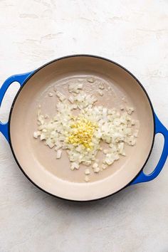 onions are being cooked in a skillet on a counter top with a blue handle