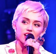 a close up of a person holding a microphone in front of a stage with lights