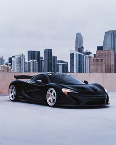 a black sports car parked in front of a city skyline