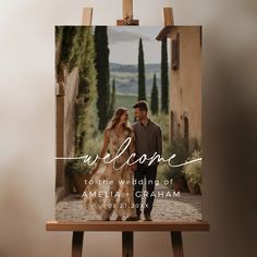 an easel with a photo of a couple on it and the words welcome to the wedding of america and graham