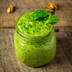 a green smoothie in a glass jar on a wooden table