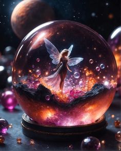 a glass ball with a fairy in it on top of a table next to planets