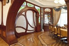 the dining room is decorated in wood and has an arched door that opens out to another room