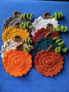 several crocheted flowers are arranged on a blue surface