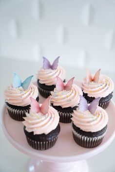 cupcakes with pink frosting and butterflies on top