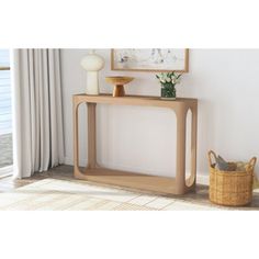 a wooden table sitting next to a window with a vase on top of it and a basket in front of it