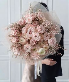 a bride holding a bouquet of pink roses