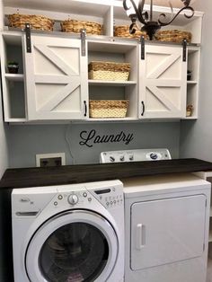 a washer and dryer in a laundry room with white cabinetry on the wall