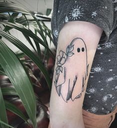 a woman's arm with a ghost tattoo on the left side of her arm