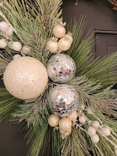 christmas wreath with disco ball ornaments and pine needles on the front door ornament