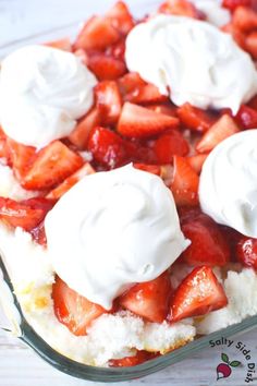 strawberry shortcake with whipped cream on top in a glass casserole dish, ready to be eaten