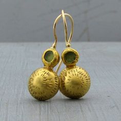 "22k gold dome and green Peridot earrings which not only bring your attire together but are also a stunning statement, look no further than these marvelous 22k solid gold earrings. The backs are secured with 9k gold while the locking French wires are handmade with 14k yellow gold. Earrings Width - 0.43''( 11 mm). Length without the ear wire - 0.7\" (17 mm). Length from top of the ear wire to bottom of the earring - 1.1\" (29 mm). The earrings will be packed in a gift box ready to give as a gift. Elegant Green Hammered Earrings, Formal Green 22k Gold Earrings, 22k Gold Gemstone Round Earrings, Traditional Hammered Yellow Gold Earrings, Silver Bar Bracelet, Dome Earrings, Organic Earrings, Vintage Drop Earrings, Gold Bar Earrings