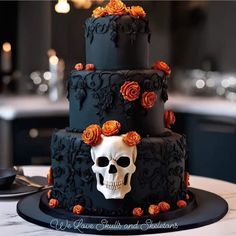 a three tiered cake decorated with black icing and orange flowers, sits on a table