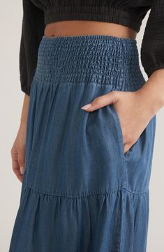 Flowy chambray lends a relaxed look to a tiered maxi skirt fitted with a comfy smocked waistband and handy slanted pockets. Smocked elastic waist Front slant pockets 100% Tencel® lyocell Tencel lyocell is a sustainably produced fiber made with closed-loop processing Machine wash, tumble dry Imported Relaxed Pleated Tiered Maxi Skirt, Summer Denim Tiered Maxi Skirt, Non-stretch Blue Tiered Maxi Skirt, Full-length Cotton Skirt With Frayed Hem, Blue Relaxed A-line Maxi Skirt, Tiered Maxi Skirt, Skirt Fits, Crop Blouse, Summer Sale