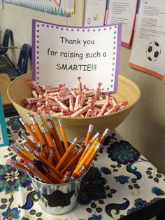 a bowl full of pencils sitting on top of a table next to a sign that says thank you for raising such a smart