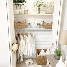 a closet with baskets and clothes hanging on the wall