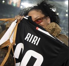 a woman holding up a shirt with the number 10 on it