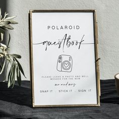 a polaroid sign sitting on top of a table next to a potted plant