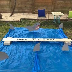 a blue tarp with shark fin designs on it and some chairs in the background