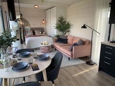 a living room filled with furniture and a dining table in front of a tv mounted to the wall