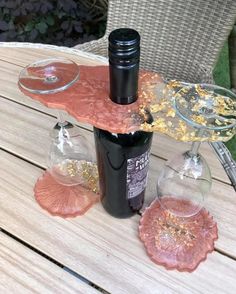 two wine glasses sitting on top of a wooden table next to a bottle of wine