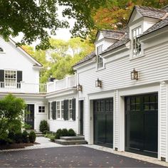 a white house with black garage doors and windows