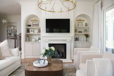 a living room filled with furniture and a flat screen tv mounted on the wall above a fireplace