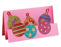 three christmas ornaments are hanging on pink card