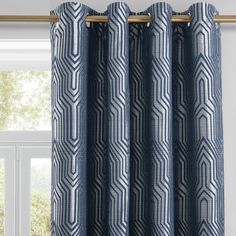 a blue and white patterned curtain hanging from a window