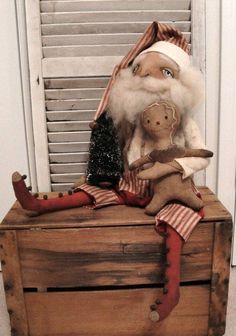 a wooden crate with a santa claus doll and other christmas decorations on top of it