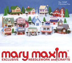 a christmas village with many small houses and trees on top of the snow covered ground