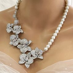 Elevate your bridal look with our Bridal Statement Earrings Necklace Set. Crafted with stunning crystal pearls and intricate orchid flowers, this unique wedding jewelry set adds a touch of elegance to your special day. Designed as the perfect gift for brides, each piece reflects meticulous attention to detail and timeless beauty. Let our set be a cherished part of your unforgettable moments. Embrace authenticity and sparkle with this exquisite ensemble. Dazzle on your special day with our exquis White Crystal Embellished Bridal Earrings For Wedding, White Flower Bridal Necklace For Wedding, Pearl White Crystal Bridal Necklace For Wedding, White Floral Bridal Necklace For Wedding, Flower Crystal Wedding Necklace, Wedding Crystal Flower Necklace, Wedding Crystal Necklace With Flower Design, Elegant White Flower Bridal Necklace, Flower Shaped Pearl Necklace For Weddings