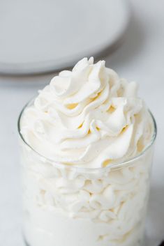 a glass jar filled with whipped cream on top of a table