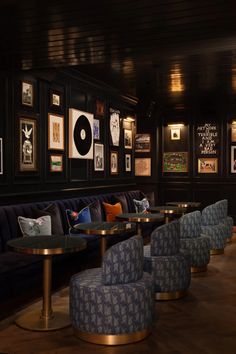 a room filled with lots of blue couches next to tables and pictures on the wall