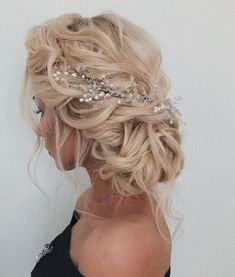 a woman with blonde hair wearing a bridal hairstyle and pearls in her hair