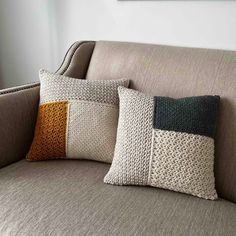 three pillows sitting on top of a couch