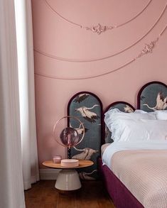 a bedroom with pink walls and two headboards on the nightstands next to each other