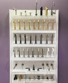 a wall mounted shelf filled with lots of different types of faucets