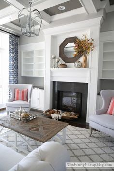 a living room with two chairs and a fire place in front of the fireplace,