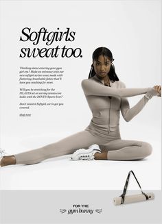 a woman is sitting on the floor with her legs spread out and holding a yoga mat