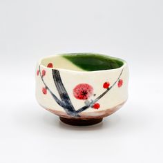 a white bowl with red and black designs on it