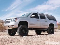 a white truck parked on top of a dirt field