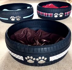 two dog beds made out of old tires with paw prints on the inside and outside