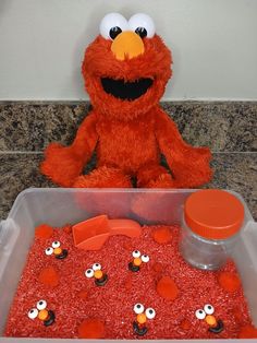 the sesame street elmo is sitting in front of an orange cake