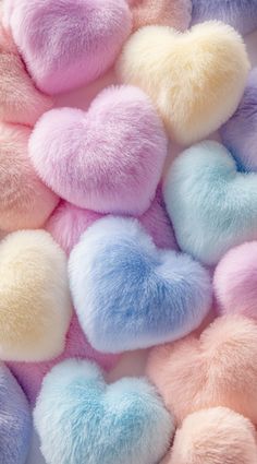 pastel heart shaped pom - poms are scattered on top of each other