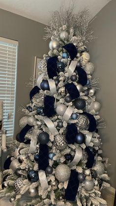 a white christmas tree with blue and silver ornaments