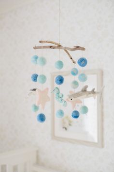 a baby crib with a blue and white mobile hanging from it's side