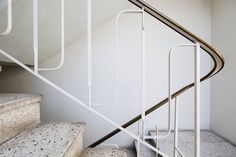 a set of stairs with handrails in an empty room next to a window