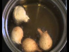 three pieces of bread are being cooked in a pot of boiling water on the stove